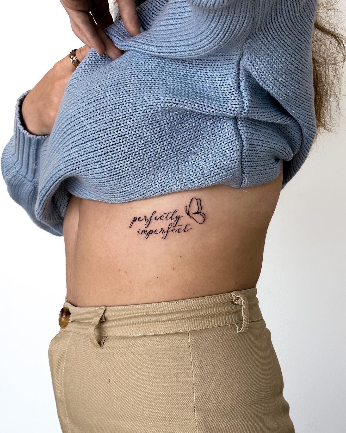 tatuagem feminina costela minimalista frase