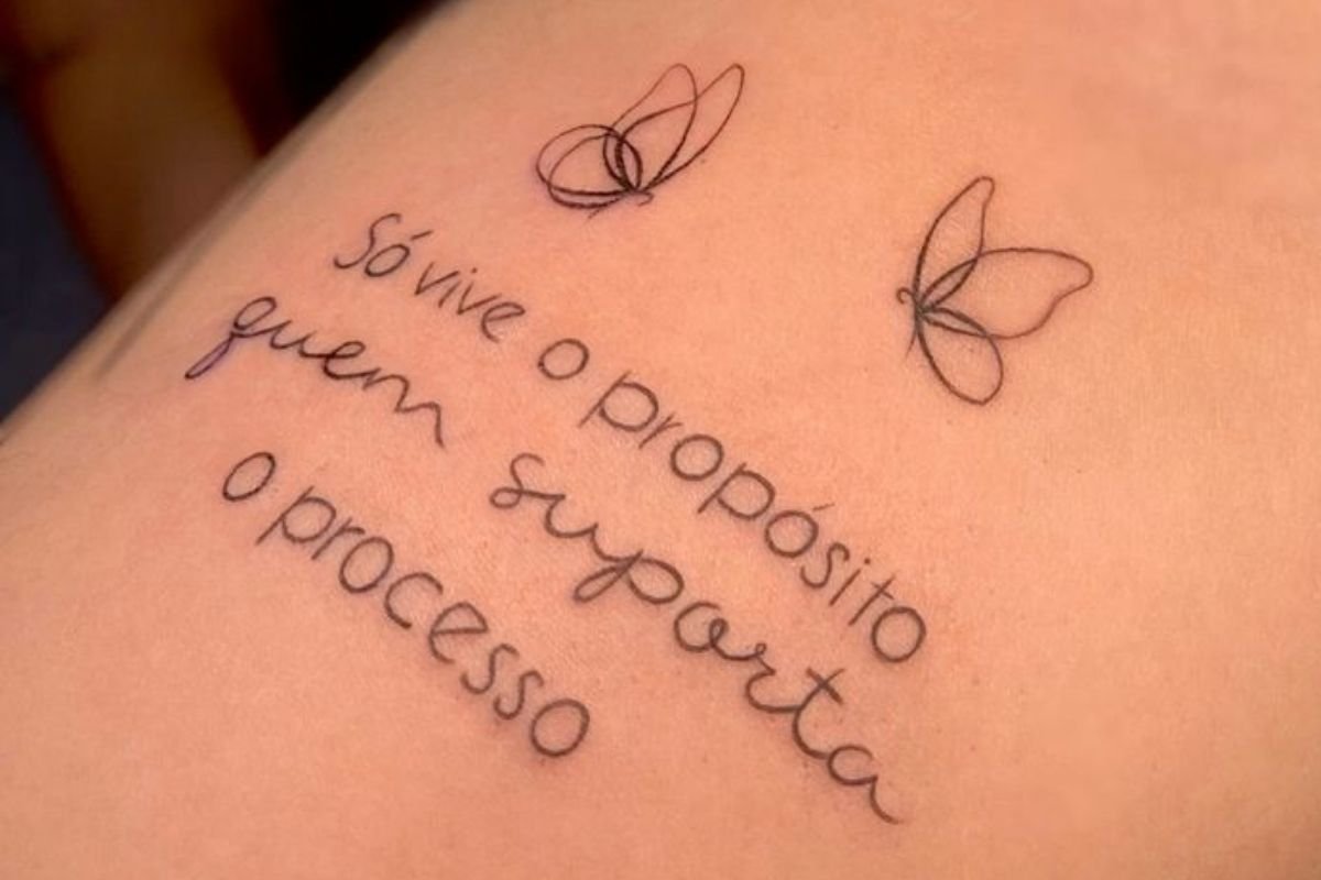 tatuagem de frase com flor na costela