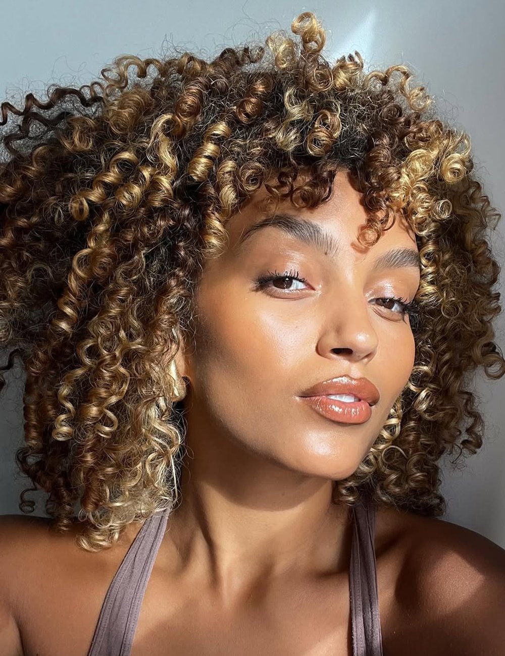 luzes caramelo em cabelo crespo