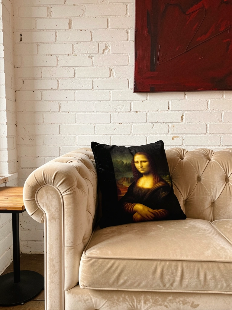 Sofá Chesterfield bege com almofada preta de Mona Lisa, parede de tijolos brancos, pintura abstrata vermelha e mesa lateral de madeira com base metálica preta.