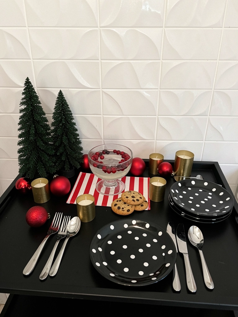 Mesa posta para ceia de Natal com toalha branca, pratos claros, talheres dourados e arranjo de pinhas e velas