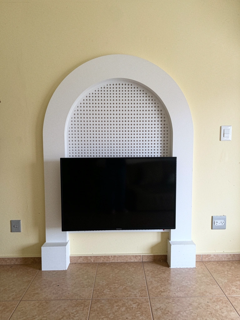 Sala de estar com painel romano vazado em tons neutros atrás da TV, iluminação suave e sofá cinza