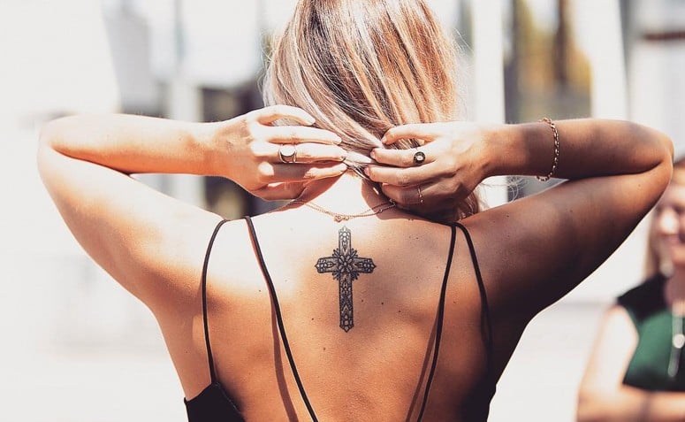 tatuagem de cruz na frente do pescoço
