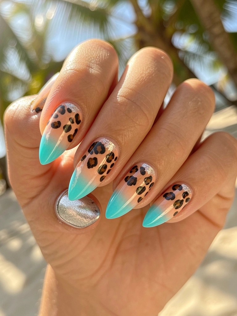 Mãos femininas com unhas alongadas em degrade de pêssego a turquesa, estampa de leopardo marrom e glitter prateado, luz difusa e fundo desfocado com claridade tropical.
