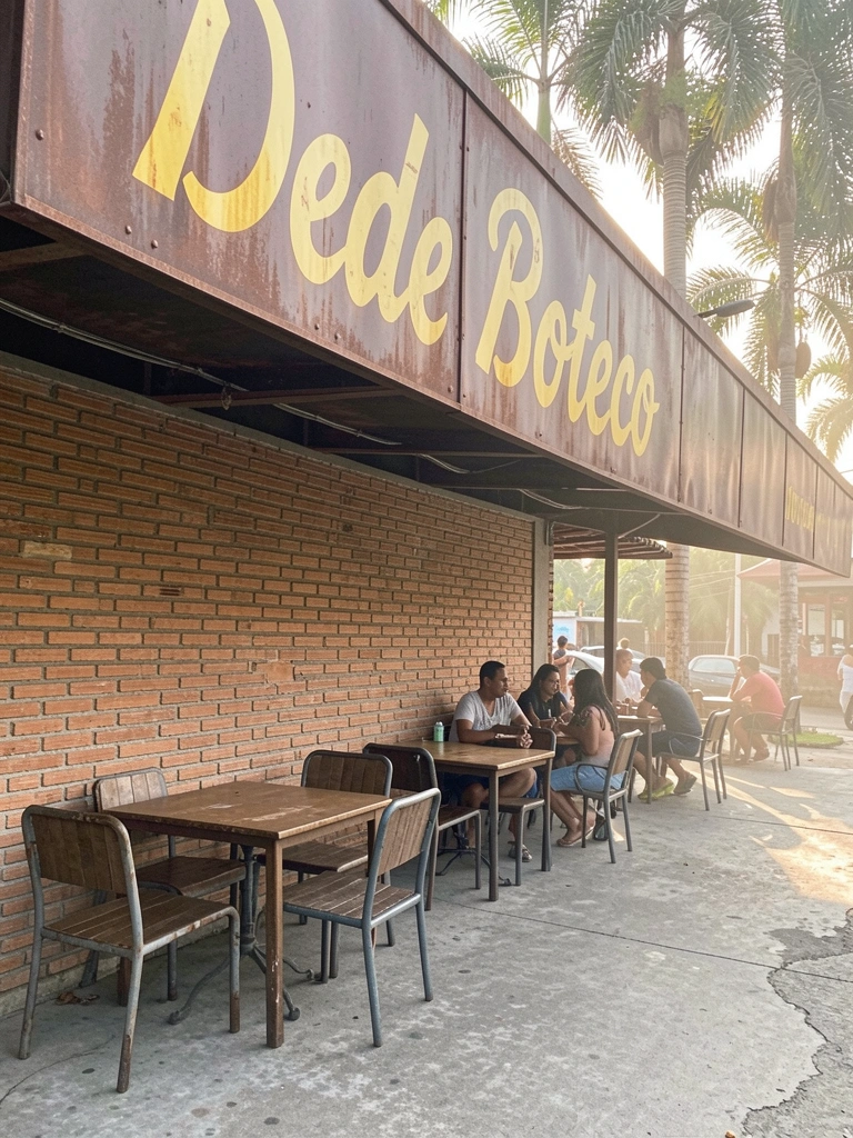 Palm trees ao fundo, toldo de metal escuro com letreiro amarelo 